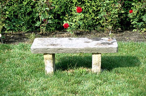 Two slabes of marble anchored in the ground, with a seat made out of another slabe.